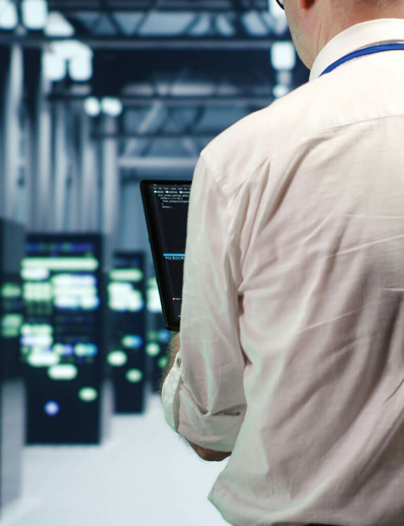 person with laptop in server room