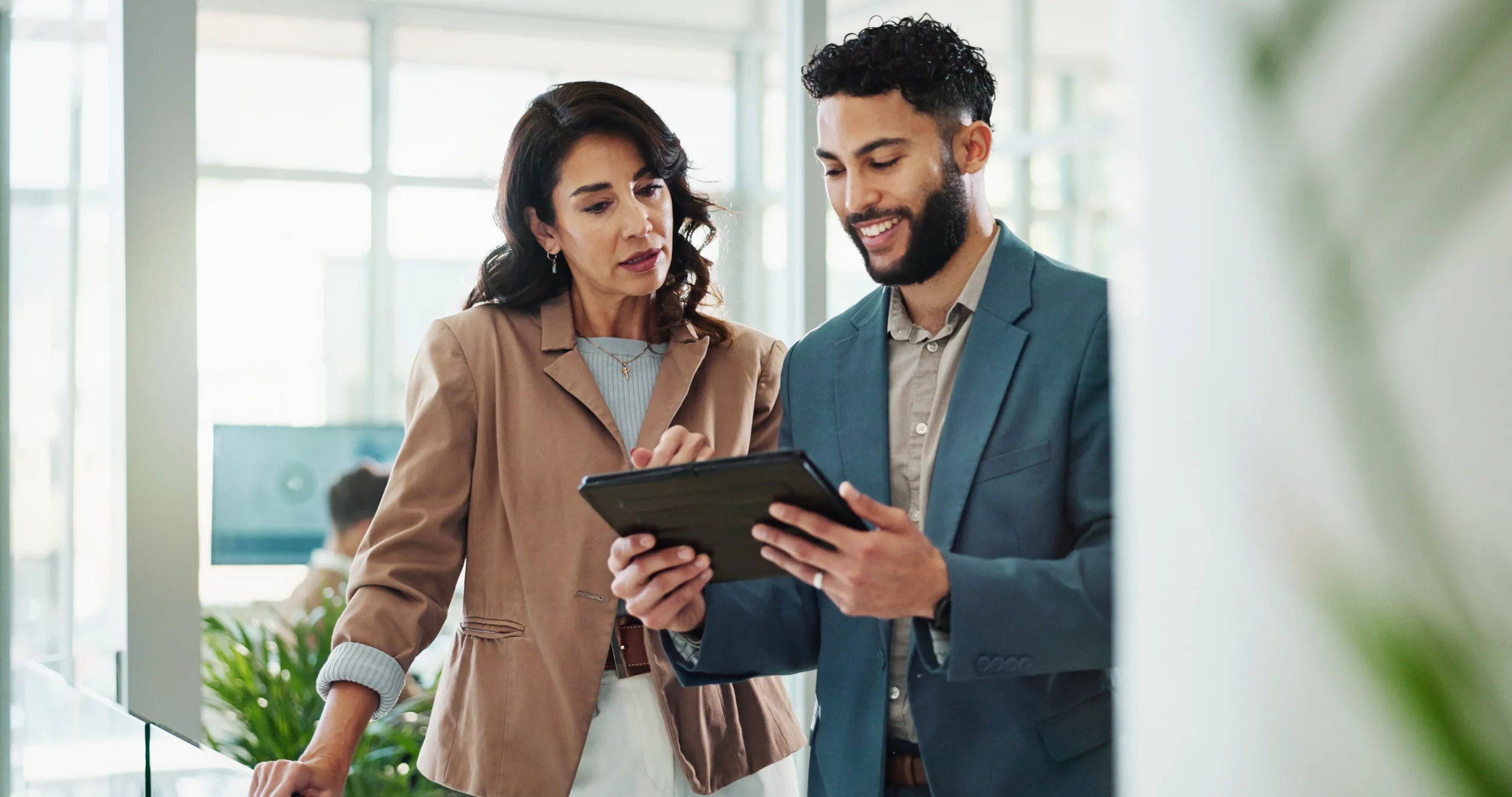two coworkers looking at tablet